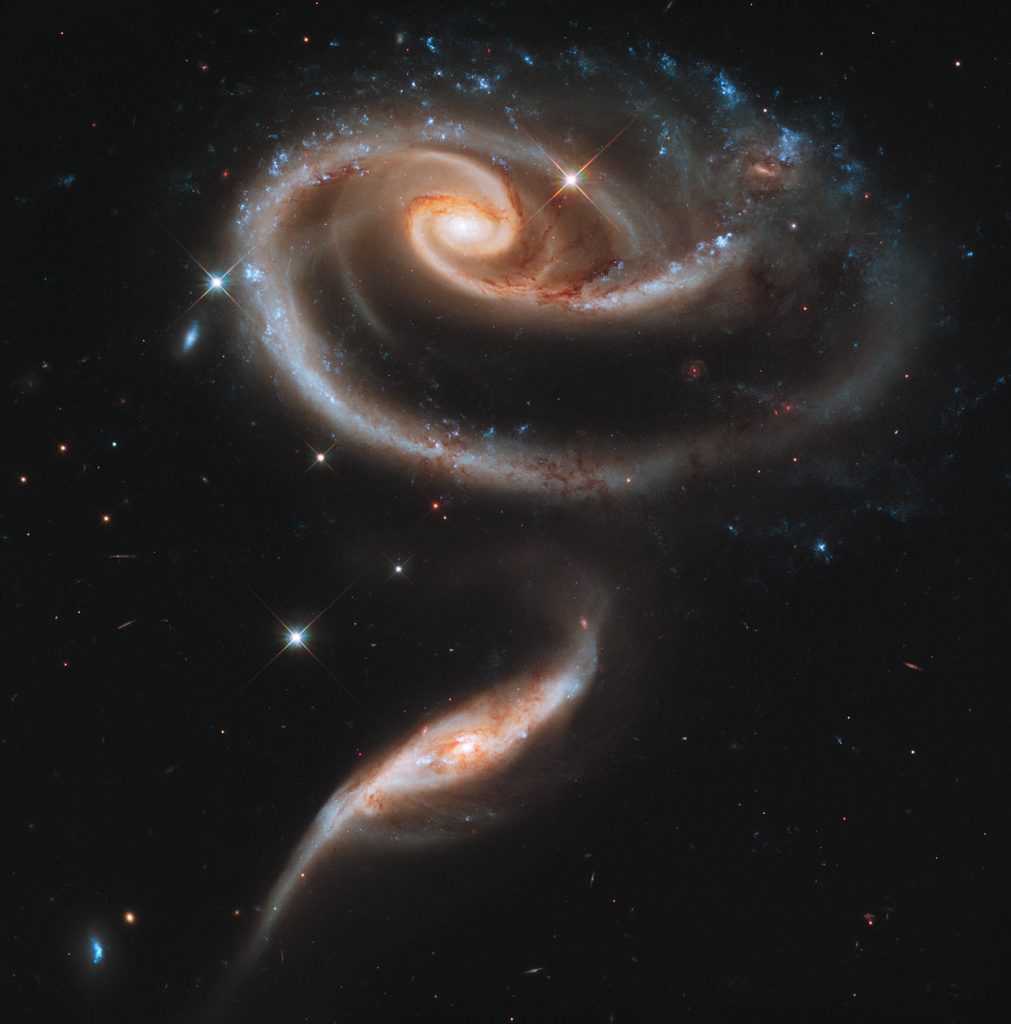 This image of a pair of interacting galaxies called Arp 273 was released to celebrate the 21st anniversary of the launch of the NASA/ESA Hubble Space Telescope. The distorted shape of the larger of the two galaxies shows signs of tidal interactions with the smaller of the two. It is thought that the smaller galaxy has actually passed through the larger one.